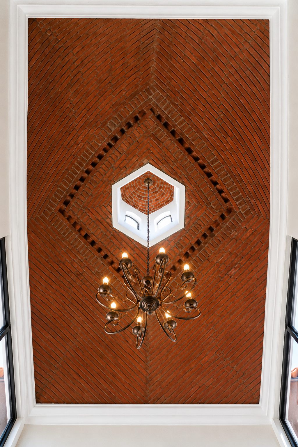 Handmade brick bóveda ceiling with hexagonal cupola skylight and wrought-iron chandelier